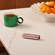 Ploom AURA Rose Gold device on a table during a coffee break.