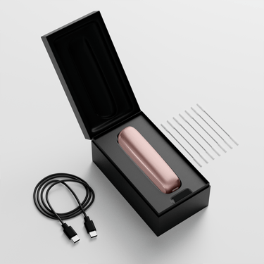 Ploom AURA open box showing the device, its charging cable and cleaning sticks.
