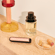 Ploom AURA front panels with Rose Gold Augmented Pattern placed on a dressing table.
