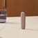 Ploom device with Rose Gold Back Cover standing on a table