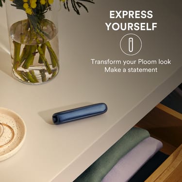 Ploom AURA device placed on a table beside a vase-5