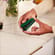 Hand placing an Amazon Green Back Cover on a Ploom AURA device