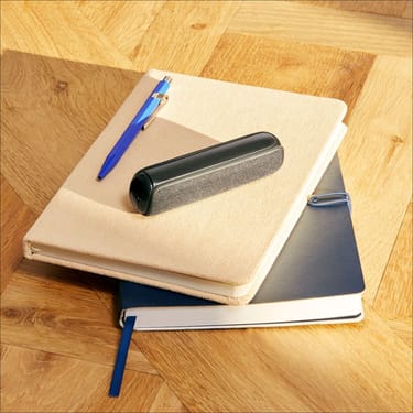 Ploom device with Jet Black Back Cover on top of a stack of notebooks