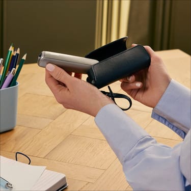 User removing a Ploom AURA device from the Solo Carry Case Jet Black accessory